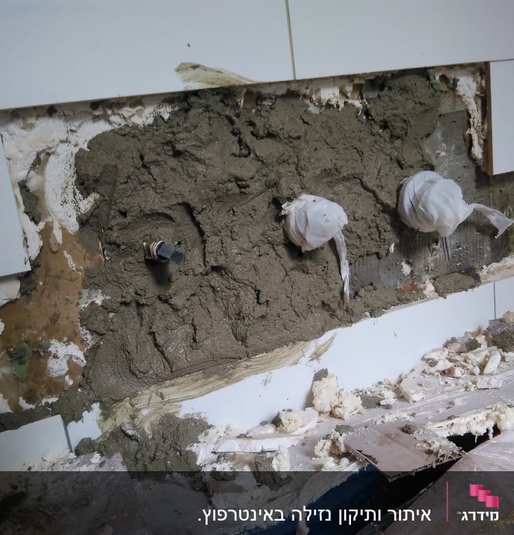 קיר פתוח עם צנרת מכוסה בטיח ותיקונים